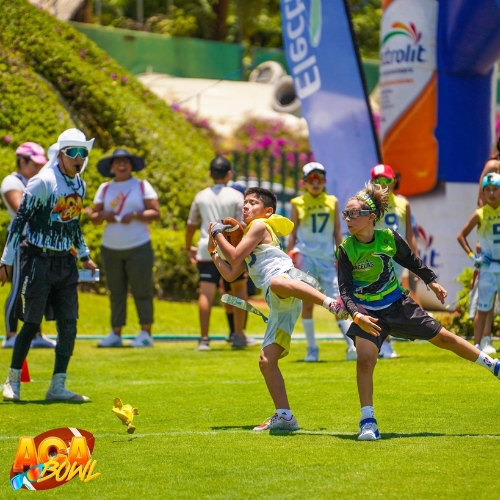 Niño atrapando balón de amerciano jugando tocho bandera